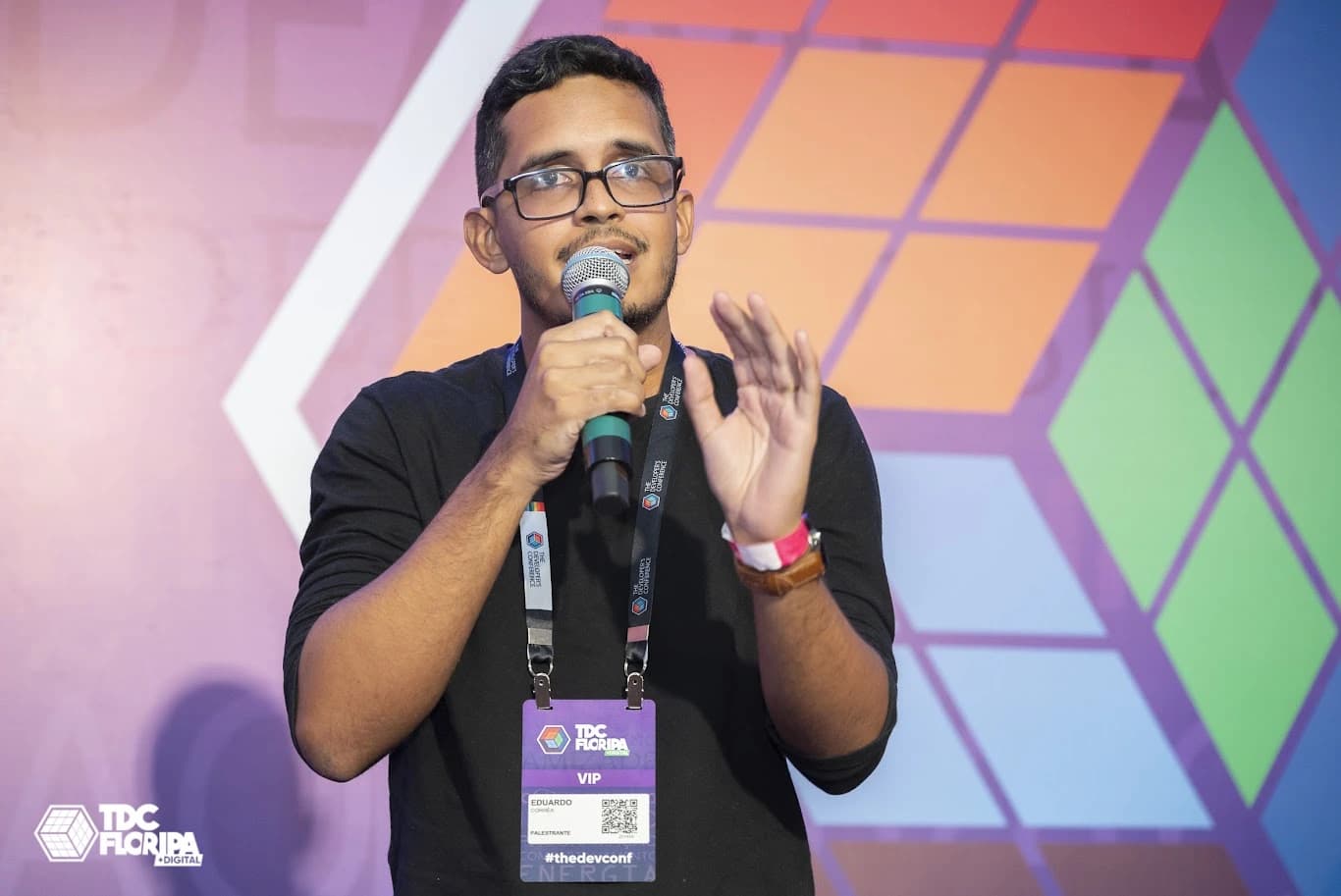 Eduardo Corrêa falando ao microfone no palco do TDC Florianópolis